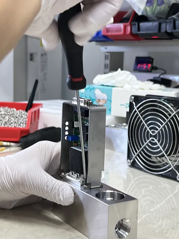 Technician assembling electronics into a mass flow controller body